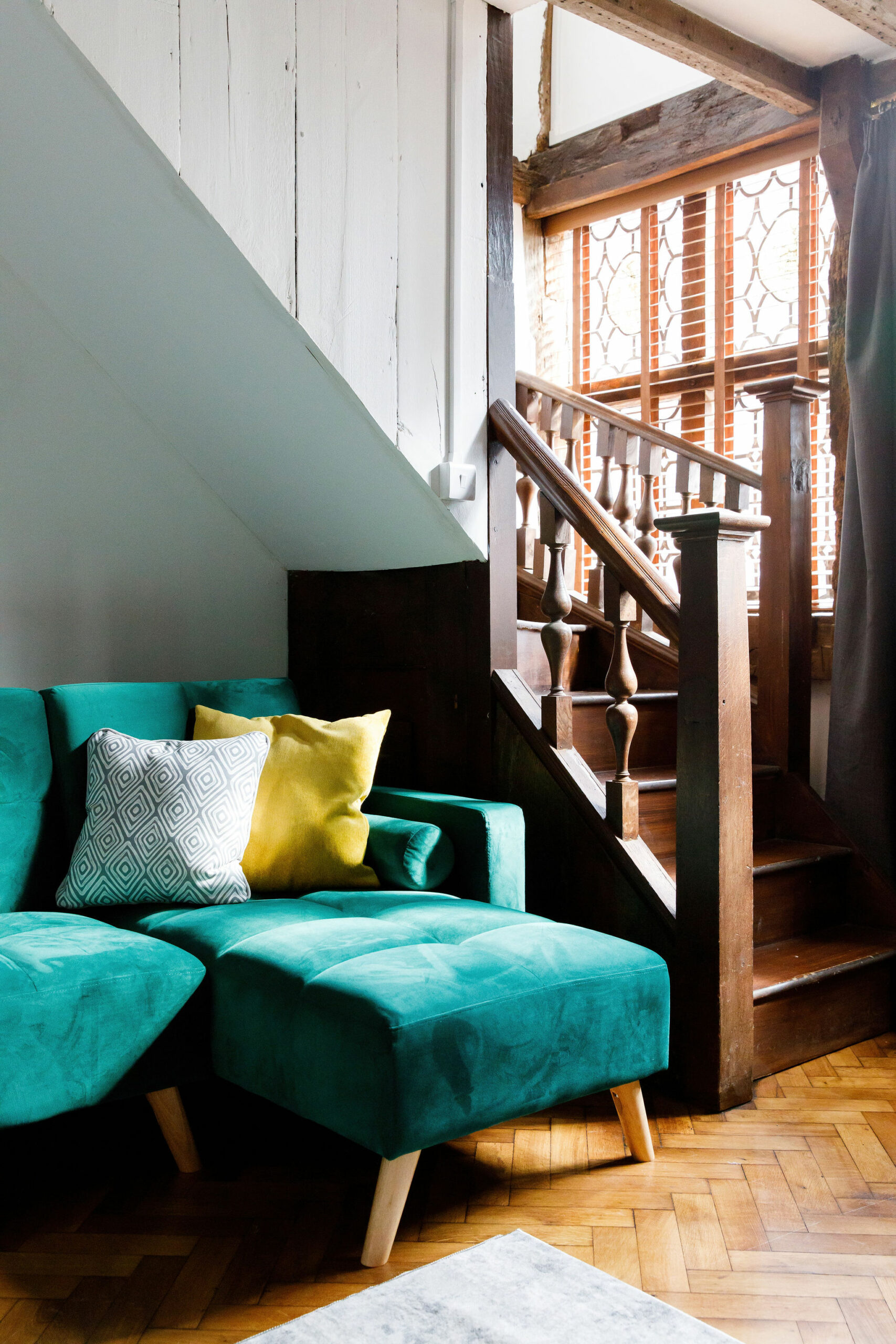 teal corner sofa and staircase in rental property